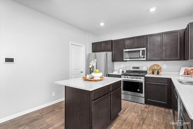 kitchen featuring dark wood-type flooring, sink, a center island, dark brown cabinets, and appliances with stainless steel finishes