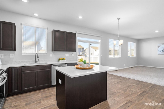 kitchen with sink, appliances with stainless steel finishes, hanging light fixtures, plenty of natural light, and a center island