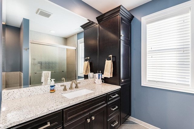 bathroom featuring an enclosed shower, vanity, and tile patterned flooring