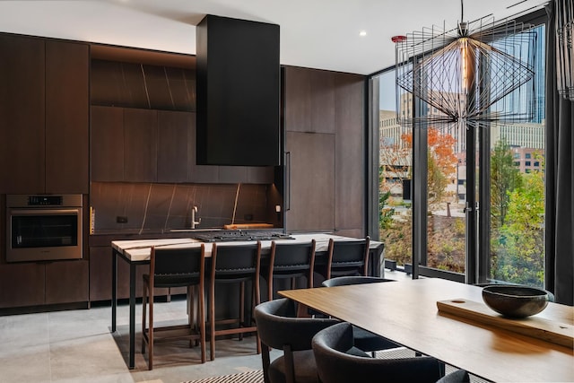 kitchen with dark brown cabinetry, stainless steel appliances, and a kitchen breakfast bar