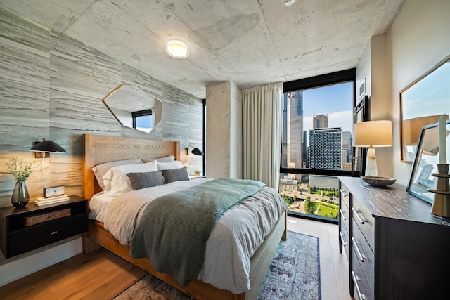 bedroom with light hardwood / wood-style flooring and floor to ceiling windows