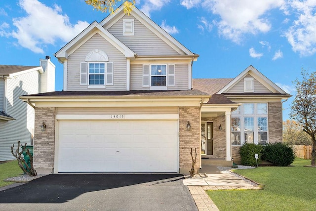 view of front of house featuring a garage and a front lawn