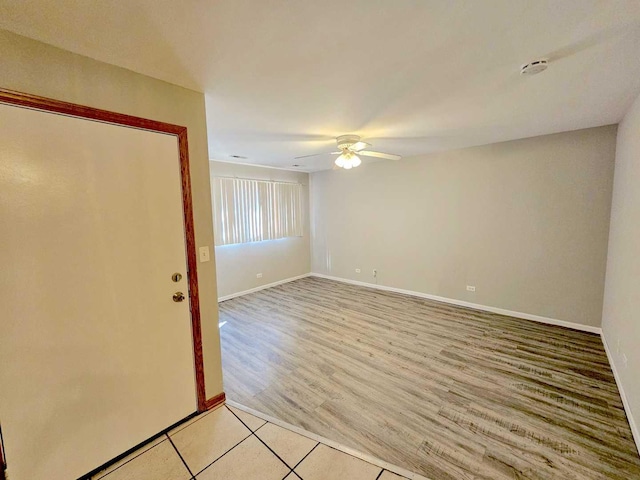 tiled spare room featuring ceiling fan