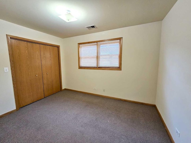 unfurnished bedroom featuring light colored carpet and a closet