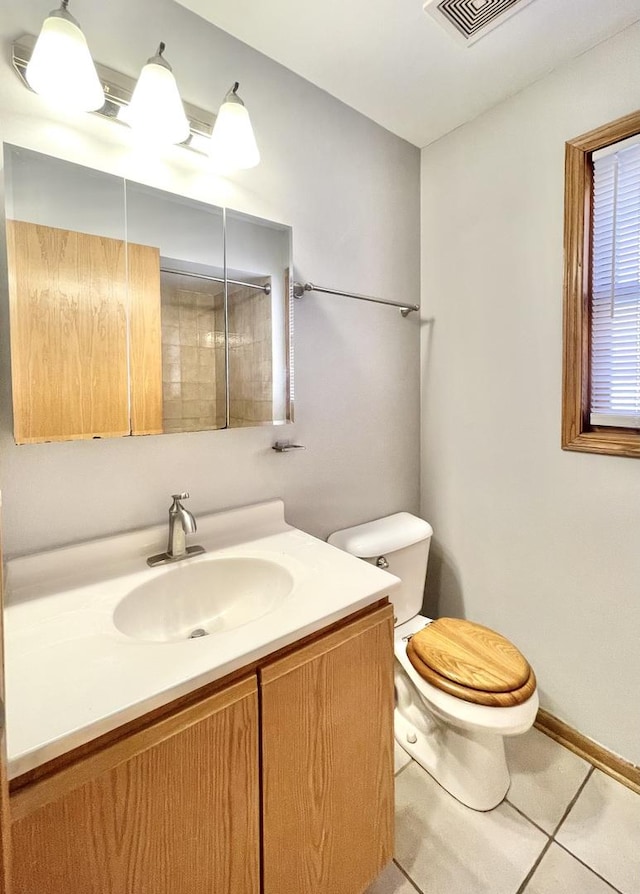 bathroom with tile patterned flooring, vanity, and toilet