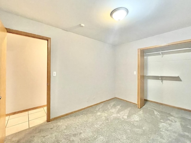 unfurnished bedroom featuring light carpet and a closet