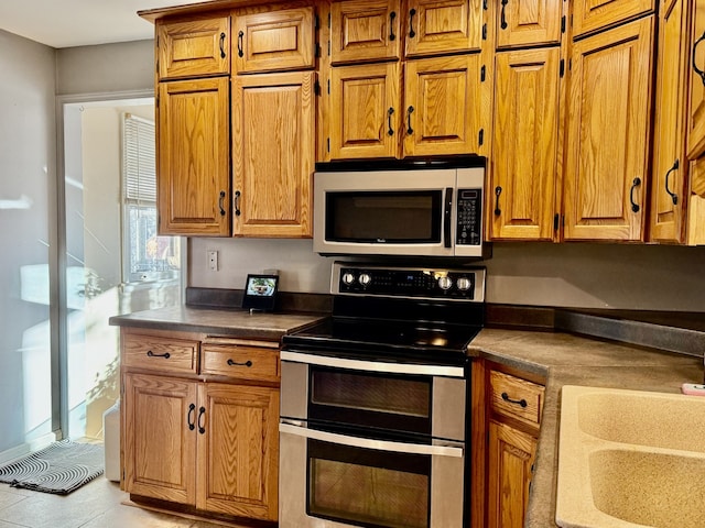 kitchen featuring appliances with stainless steel finishes, sink, and light tile patterned floors