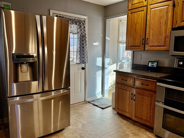 kitchen featuring appliances with stainless steel finishes and a healthy amount of sunlight