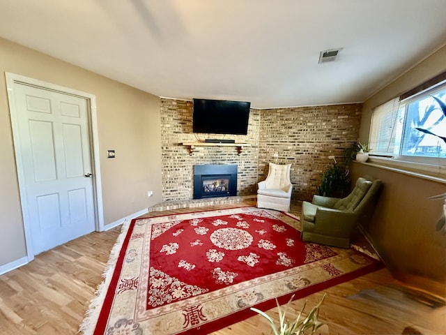 sitting room with a fireplace and hardwood / wood-style floors