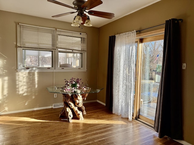 dining space with hardwood / wood-style floors and ceiling fan