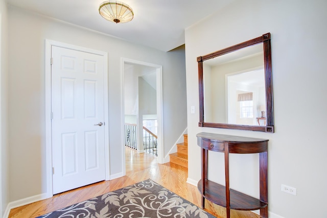 corridor with stairs, baseboards, and wood finished floors