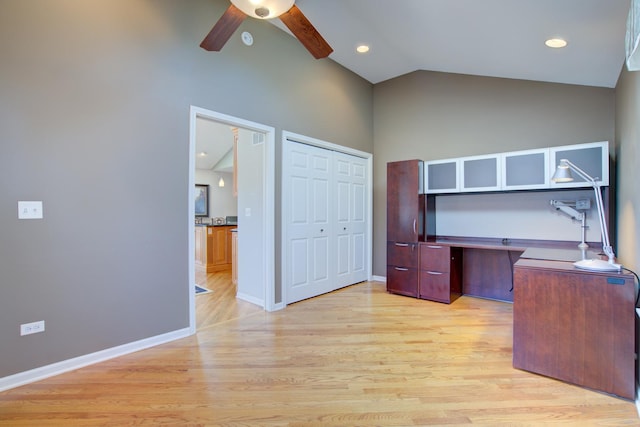 unfurnished office featuring baseboards, light wood-style flooring, and vaulted ceiling