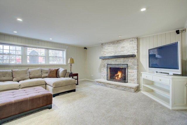 living room featuring a stone fireplace, recessed lighting, and carpet