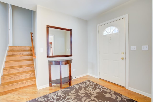 entrance foyer featuring stairs, wood finished floors, and baseboards