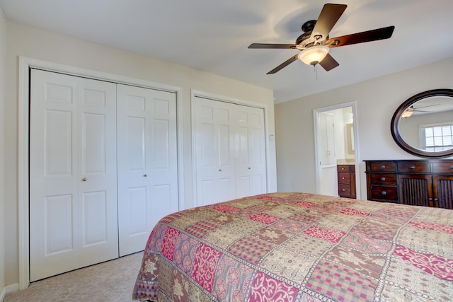 bedroom featuring two closets, ceiling fan, and carpet