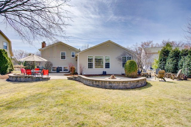 rear view of house featuring a patio area, a lawn, and an outdoor fire pit