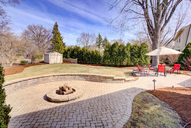 view of patio with an outdoor structure, a fire pit, and a shed