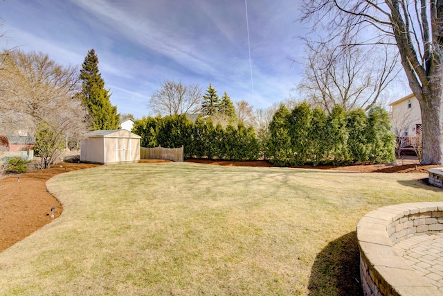 view of yard with an outbuilding, a storage shed, and fence