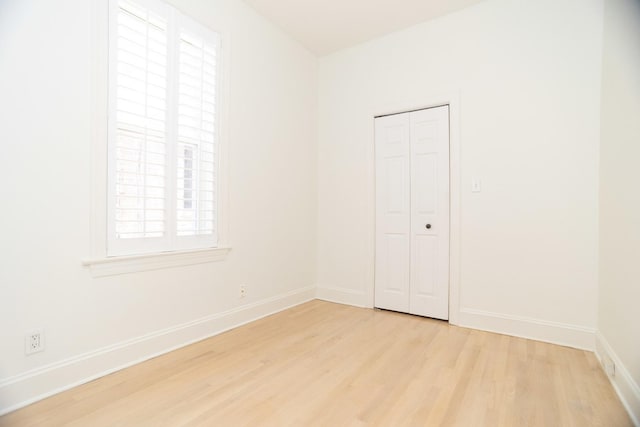 spare room featuring light wood-style flooring and baseboards