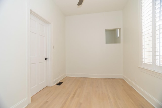 unfurnished room featuring visible vents, a ceiling fan, light wood-type flooring, and baseboards