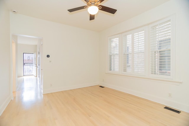 spare room with visible vents, baseboards, light wood-style flooring, and a ceiling fan