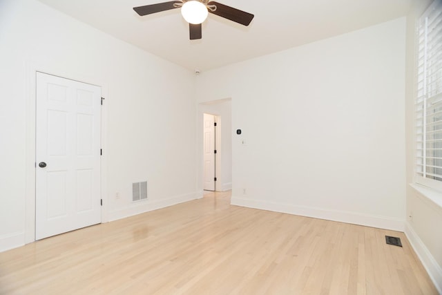 empty room with visible vents, baseboards, light wood-style floors, and ceiling fan