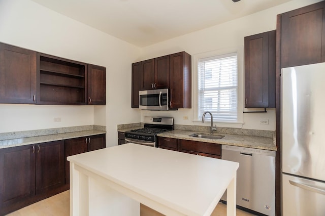 kitchen with a sink, dark brown cabinetry, light countertops, appliances with stainless steel finishes, and open shelves