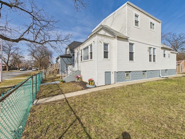 view of home's exterior with a lawn and fence