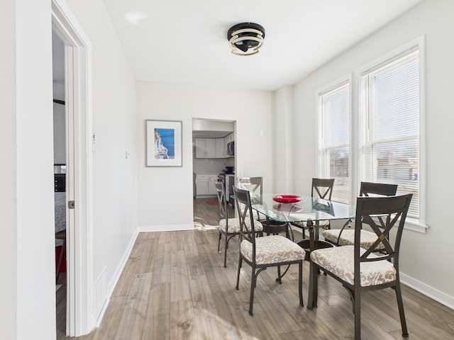 dining space with wood finished floors and baseboards