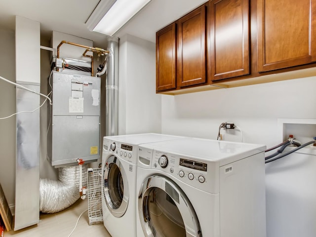 laundry room featuring washer and dryer and cabinets