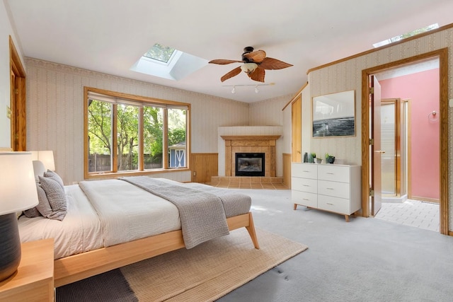 665 S Circle Ave, Port Barrington, IL 60010 - bedroom featuring wallpapered walls, a skylight, a tiled fireplace, light colored carpet, and a ceiling fan