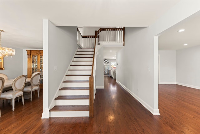 stairs featuring an inviting chandelier and hardwood / wood-style floors