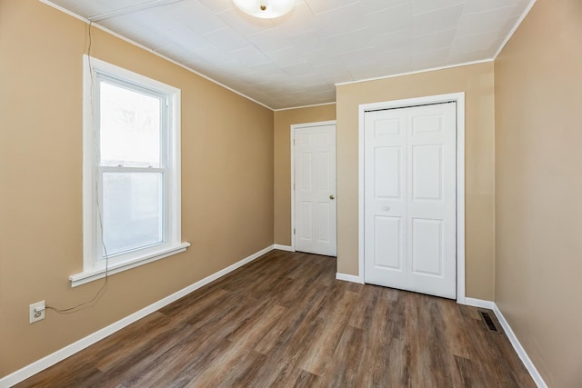 unfurnished bedroom featuring a closet and dark hardwood / wood-style floors