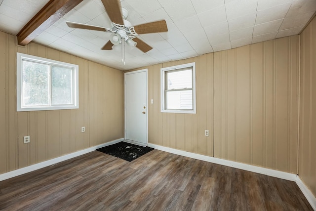 interior space featuring dark hardwood / wood-style flooring, ceiling fan, a wealth of natural light, and beamed ceiling