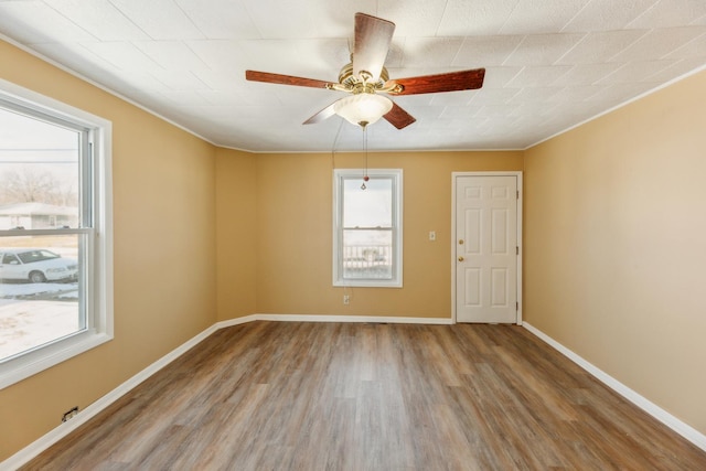 spare room featuring hardwood / wood-style flooring, a healthy amount of sunlight, and ceiling fan