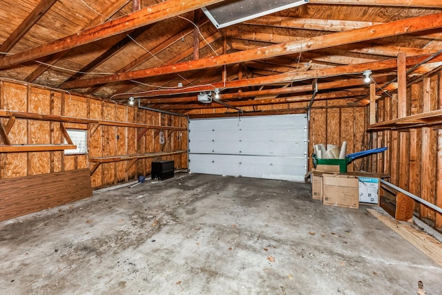 garage featuring a garage door opener and wooden walls