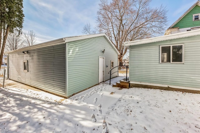 view of snow covered exterior with an outbuilding