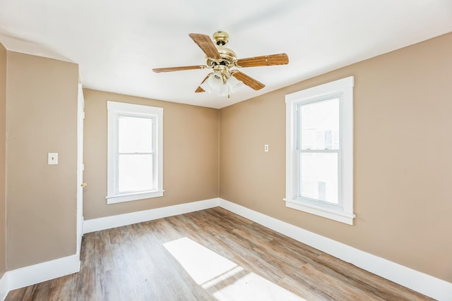 unfurnished room featuring hardwood / wood-style flooring, ceiling fan, and a wealth of natural light