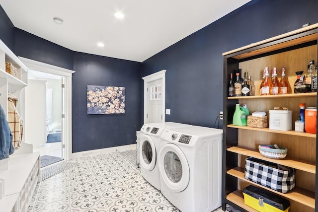 washroom featuring laundry area, separate washer and dryer, tile patterned flooring, and baseboards