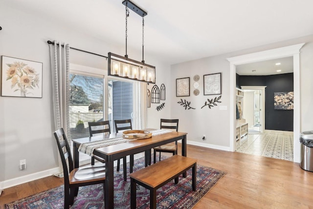 dining space featuring a healthy amount of sunlight, wood finished floors, and baseboards