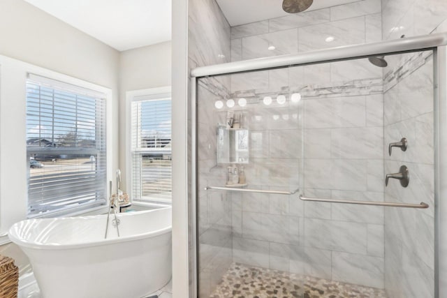 full bathroom featuring a stall shower and a freestanding bath