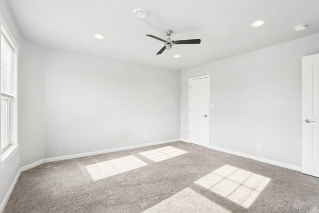 carpeted spare room featuring ceiling fan