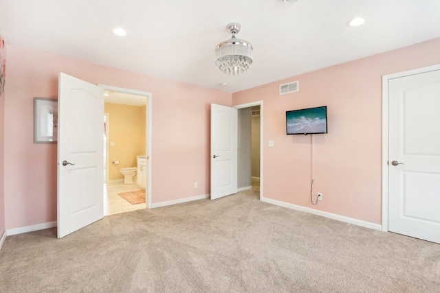 unfurnished bedroom with recessed lighting, light colored carpet, visible vents, ensuite bathroom, and baseboards