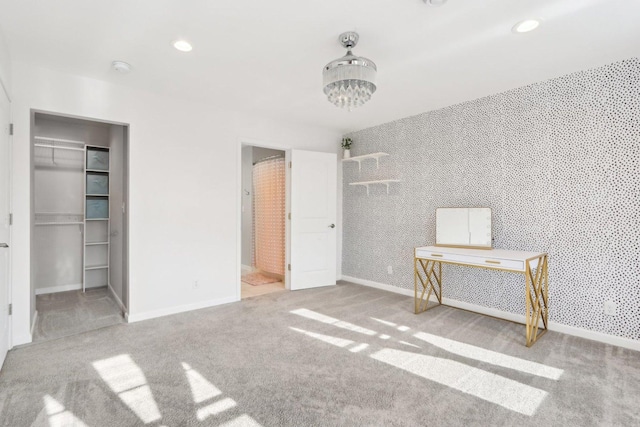 unfurnished bedroom featuring a spacious closet, recessed lighting, carpet flooring, and wallpapered walls