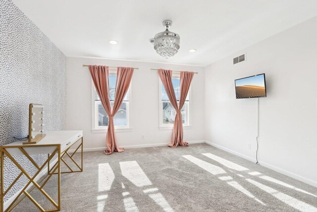 unfurnished bedroom featuring an inviting chandelier, a spacious closet, a closet, and carpet flooring