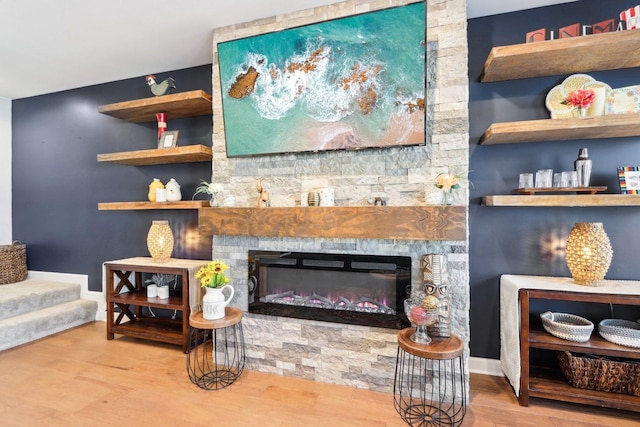 living room with hardwood / wood-style flooring, a fireplace, and built in features