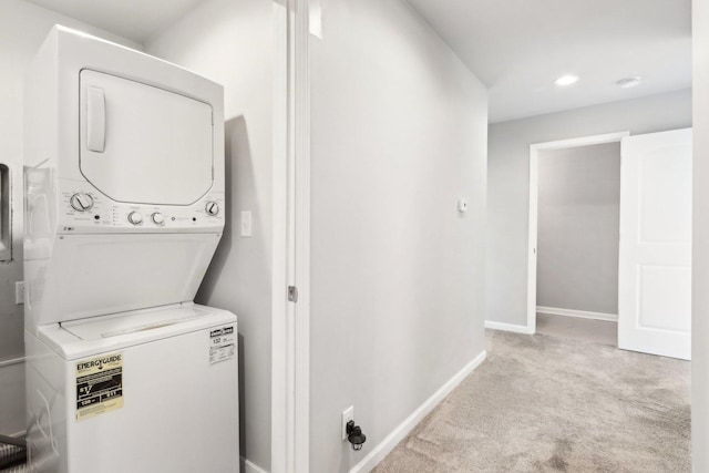 laundry area with light carpet and stacked washer and clothes dryer