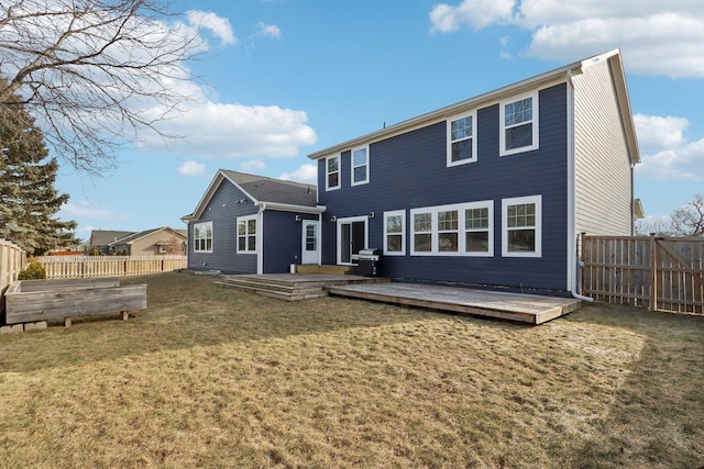 back of house featuring a garden, a fenced backyard, a lawn, and a wooden deck