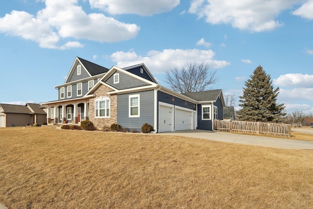 view of front of property featuring driveway, a porch, an attached garage, fence, and a front lawn