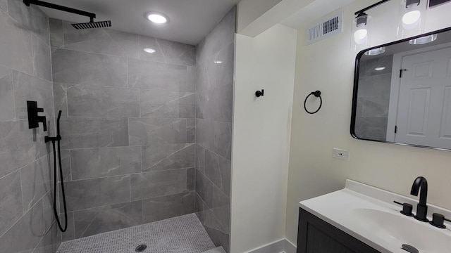 bathroom with vanity and tiled shower